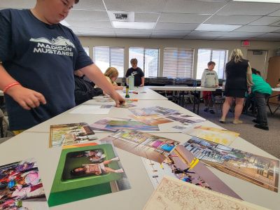 Elementary students pick from assorted photographs to help display their design ideas for a new school.